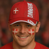 En smilende mand iført en rød kasket med teksten 