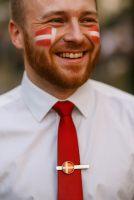 Mand med Dannebrog malet på kinden og slipsenål med dannebrog