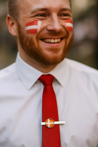 Mand med Dannebrog malet på kinden og slipsenål med dannebrog