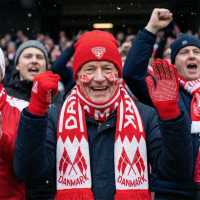 Dansk roligan iført Danmark hue, halstørklæde og handsker på stadion