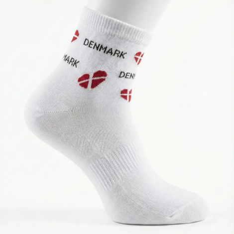 Nærbillede af hvid ankelsok med mønster af røde hjerteformede Dannebrogsflag og 'DENMARK' tekst.