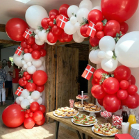 Et billede af en stor, imponerende ballonbue lavet af røde og hvide latexballoner i forskellige størrelser.