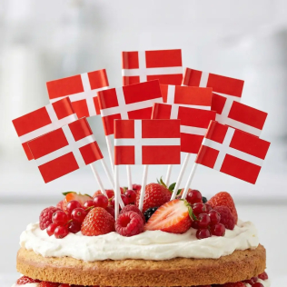 Nærbillede af Dannebrog kageflag sat i en flødeskagkage