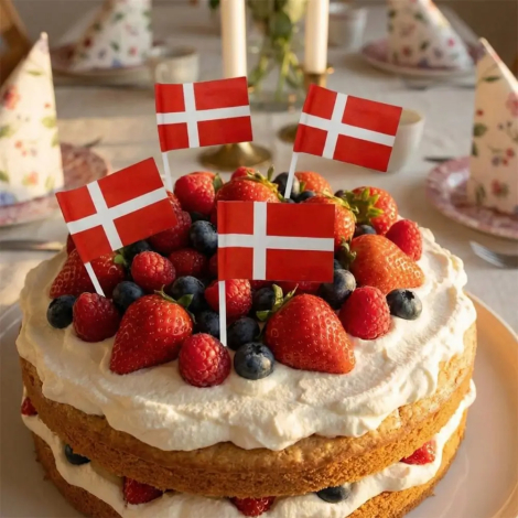 Lækker dansk lagkage med flødeskum og friske bær pyntet med små Dannebrogsflag på pinde.