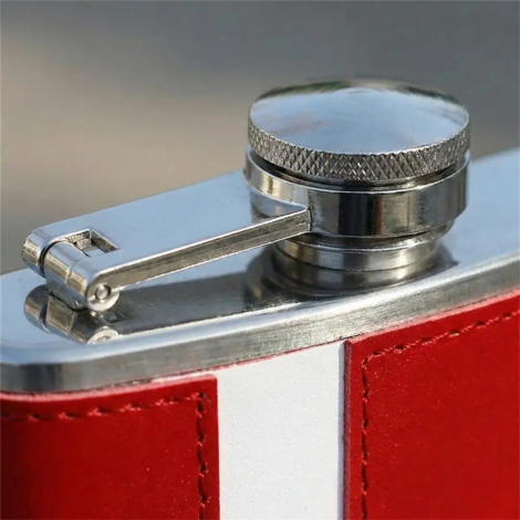 Toppen på Danmark lommelærke i rustfrit stål. Fokus er på det riflede skruelåg og hængselmekanismen, der viser solid byggekvalitet. Man ser tydeligt teksturen i det røde og hvide læder, der møder stålkanten