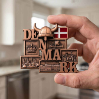 Person har danmark bronze magnet i hånden for at vise størrelsen på den