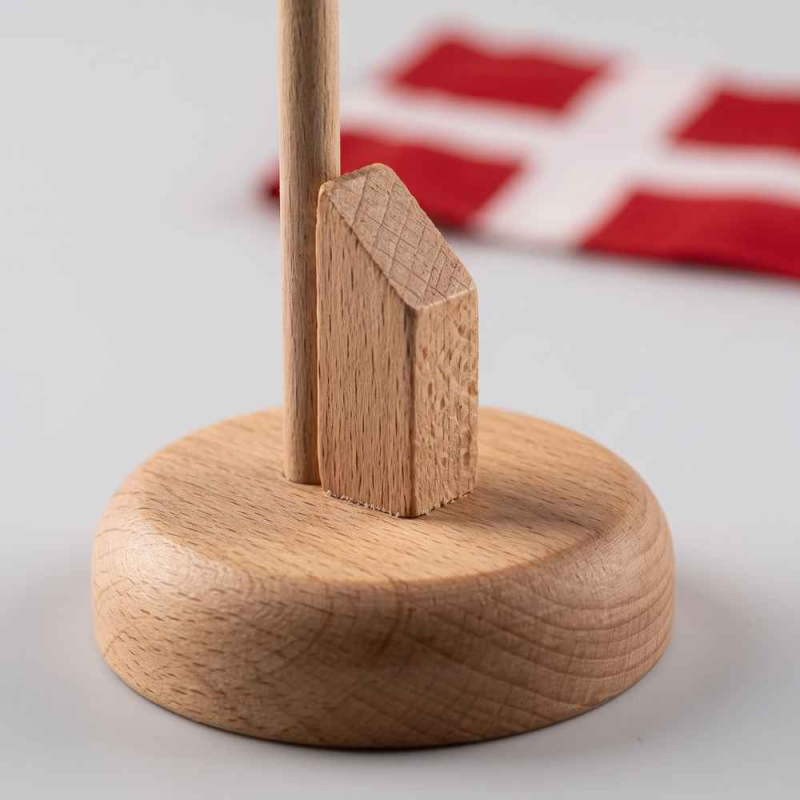 Detaljeret nærbillede af den stabile træfod til det 25 cm høje Dannebrog bordflag, der viser træets åretegninger og en skrå træholder.