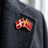 Dansk og kinesisk flag pin siddende på en jakke